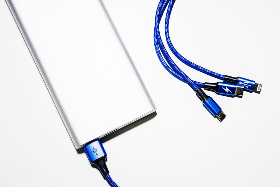 A power bank with blue USB charging cables on a white background