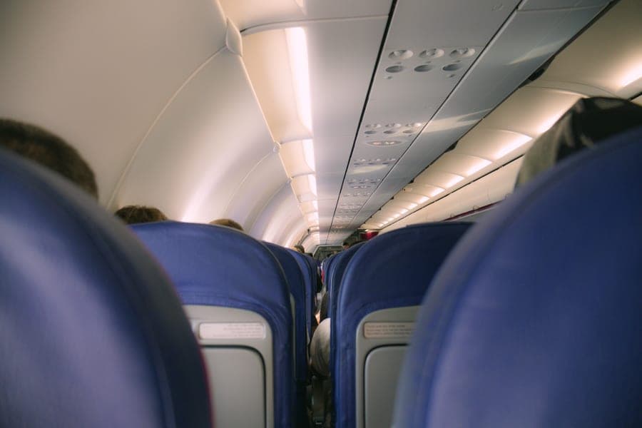 A view of a modern airplane cabin showing rows of seats and overhead compartments