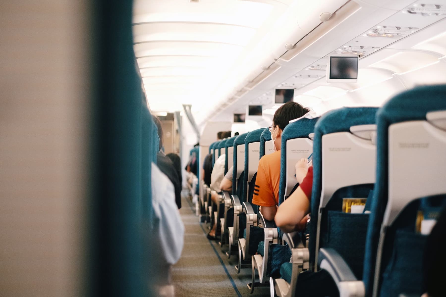 The interior of an airliner cabin with passengers seated during a flight