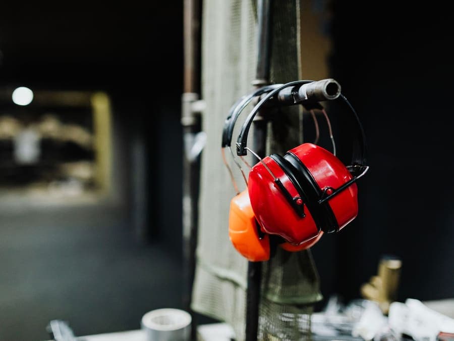 Ear defenders with a padded headband hanging on a rail