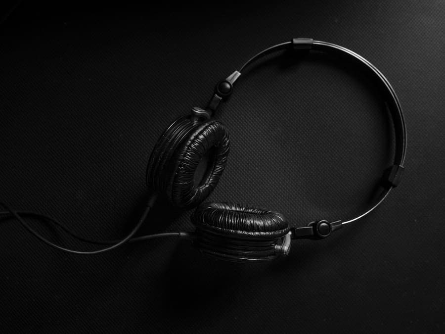 Small wired headphones photographed on a dark textured background