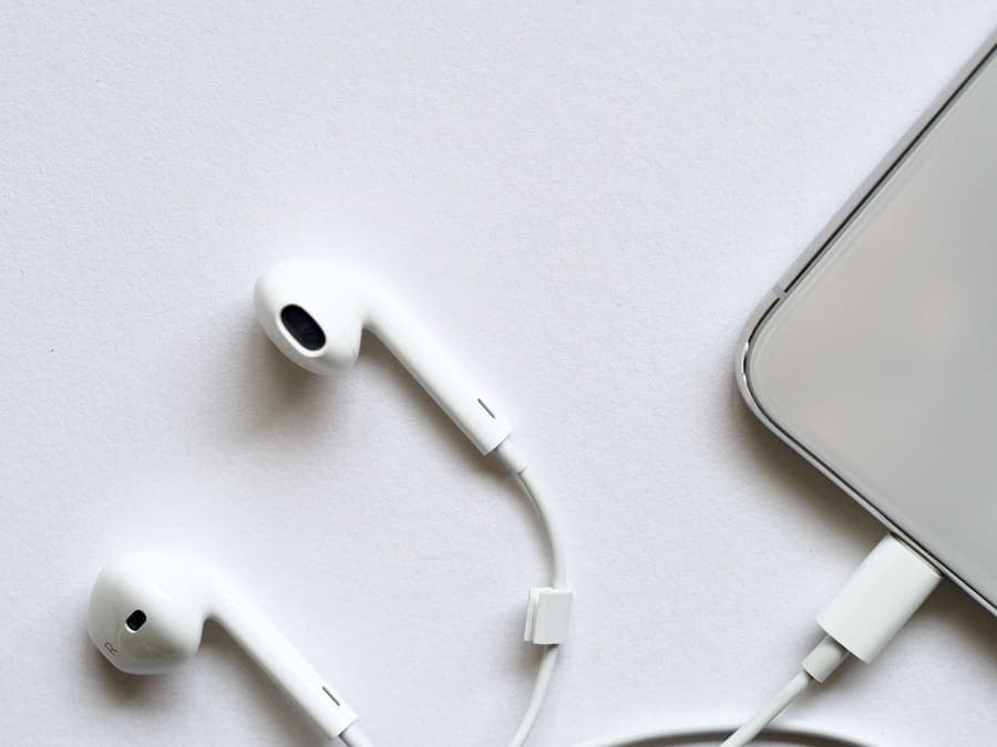 White wired earphones with a cable on a plain background
