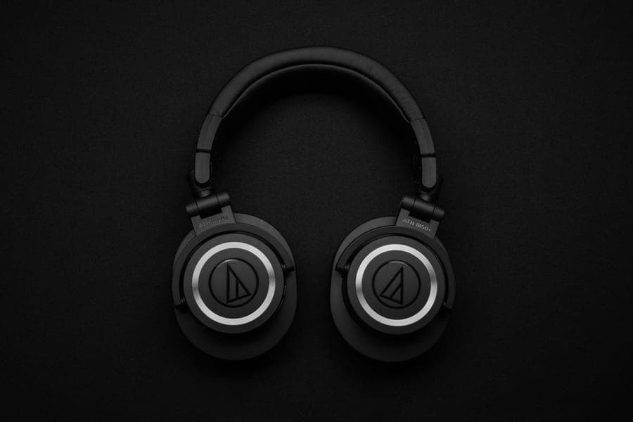Matte black over-ear headphones with fold-flat earcups on a dark surface
