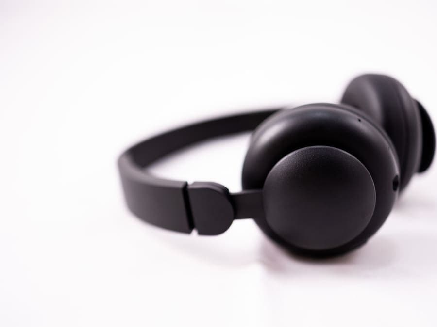 Shiny black wireless headphones on a white studio surface