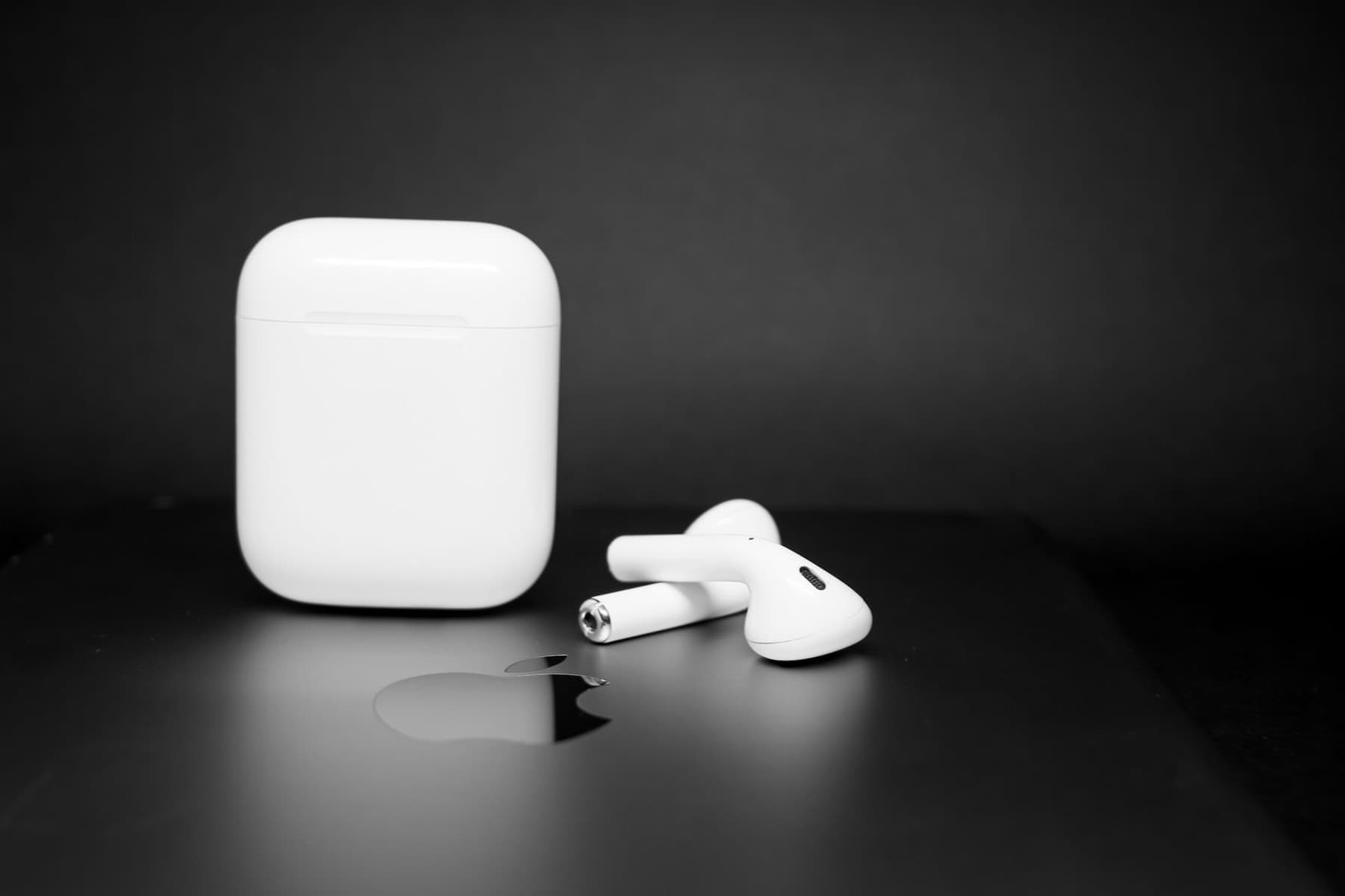 An Android smartphone beside a wireless earbud charging case