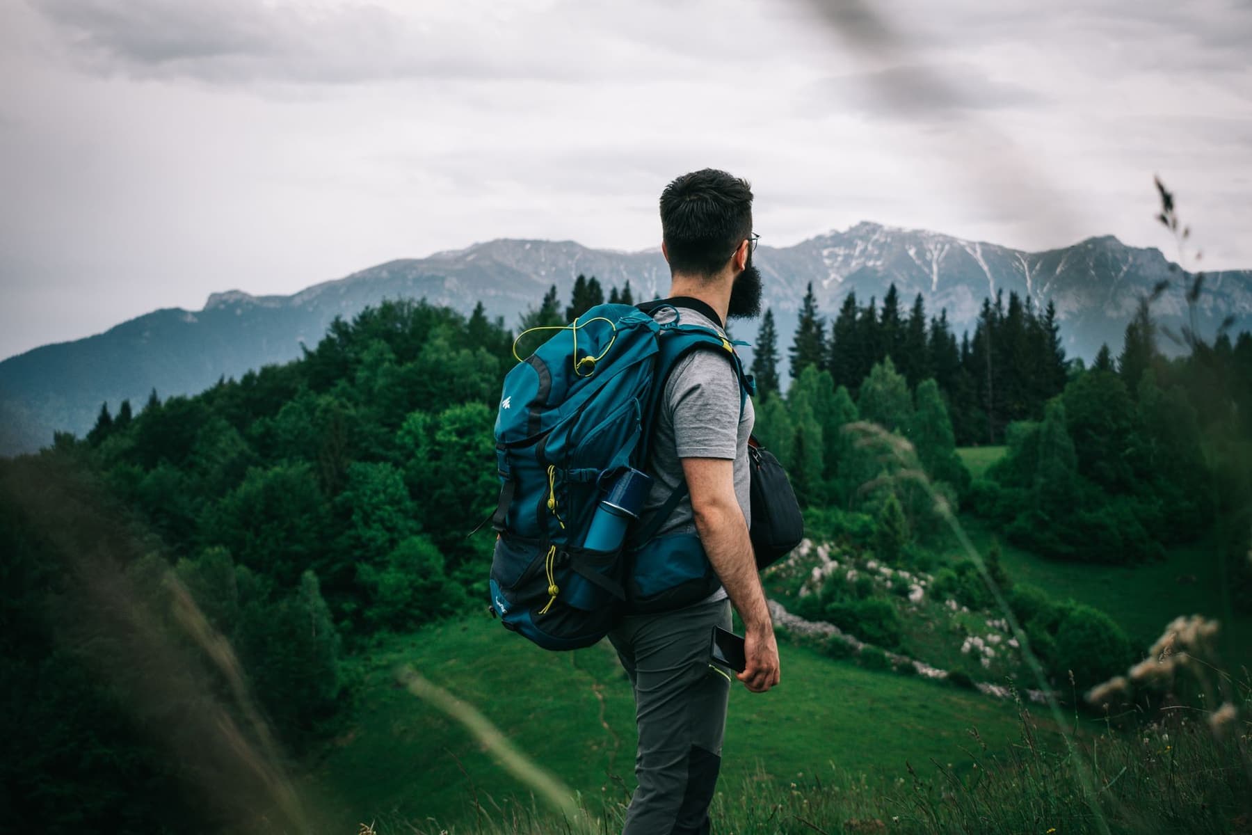 A hiker with a backpack walking through mountain scenery