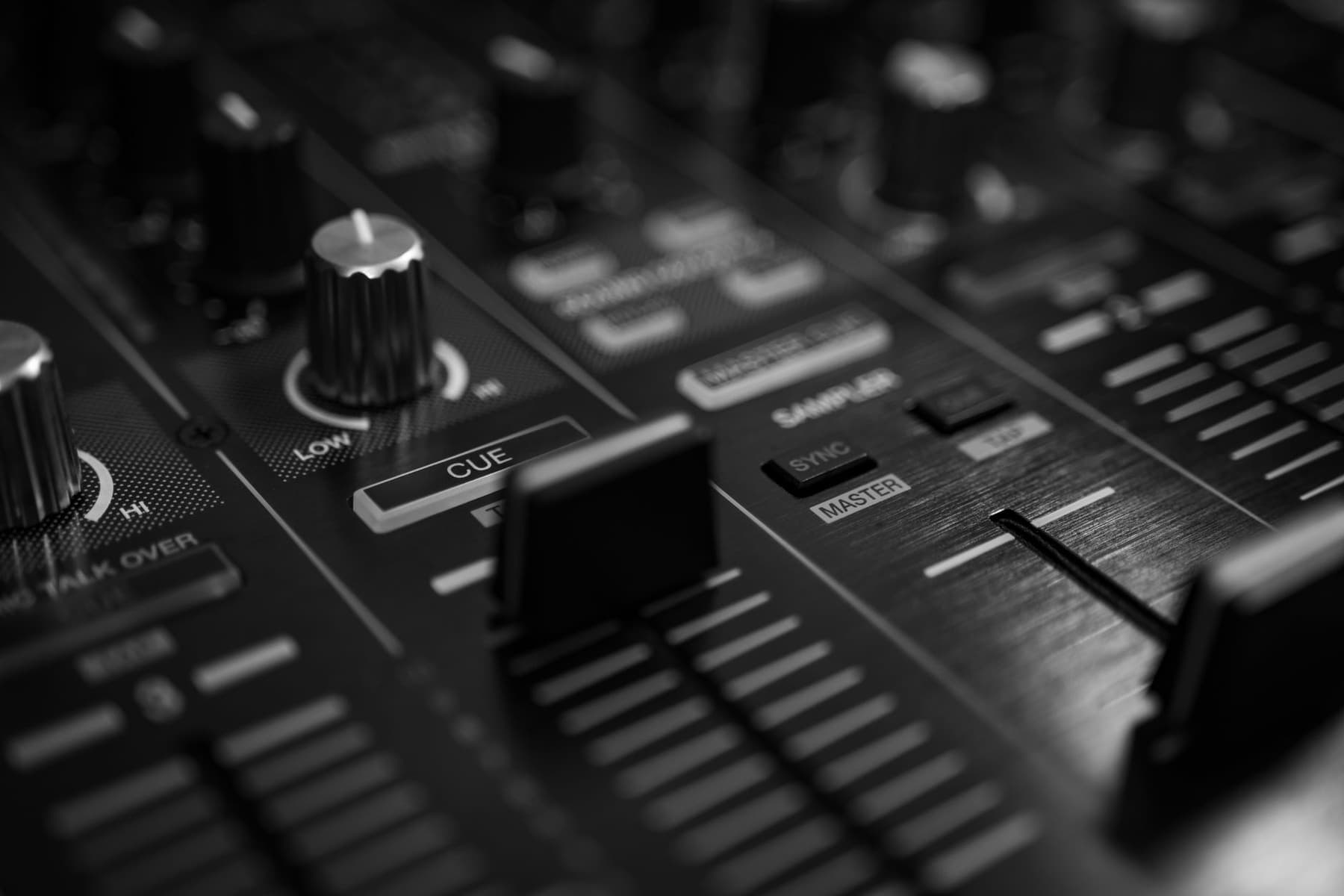 Close-up of a DJ mixer and a row of audio faders