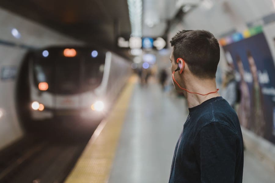 A commuter waiting on a subway platform as a train approaches