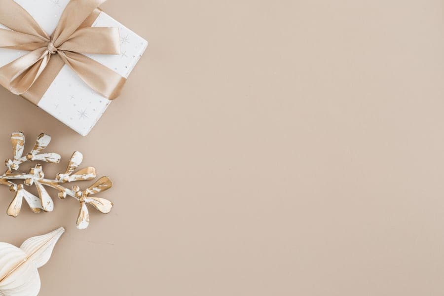 A wrapped gift box with a bow on a neutral background