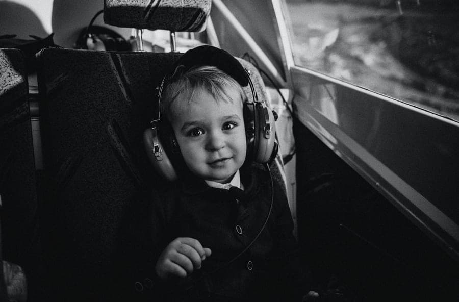 A young child wearing aviation headphones in an airplane seat