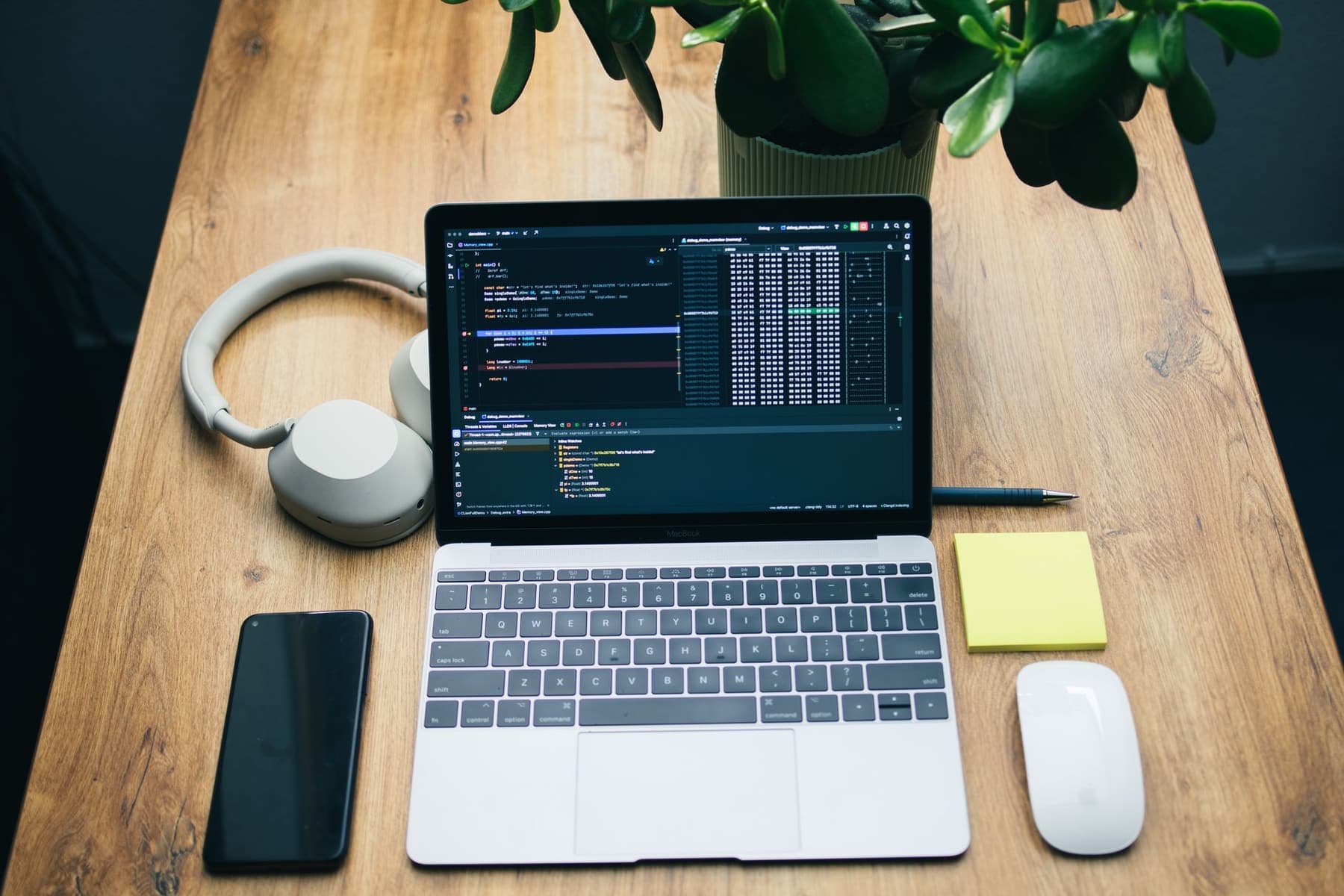 A desk with a laptop, a smartphone and over-ear headphones