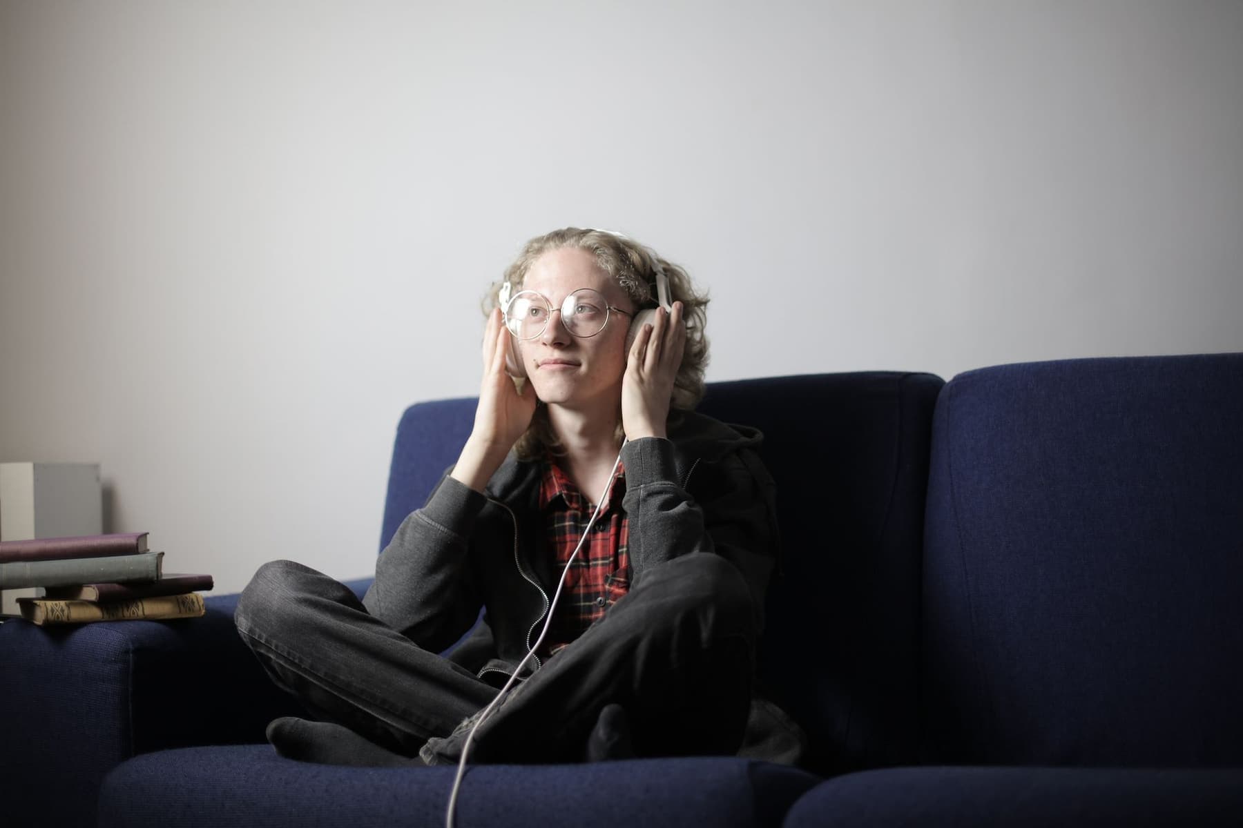 A person relaxing at home listening to music through headphones