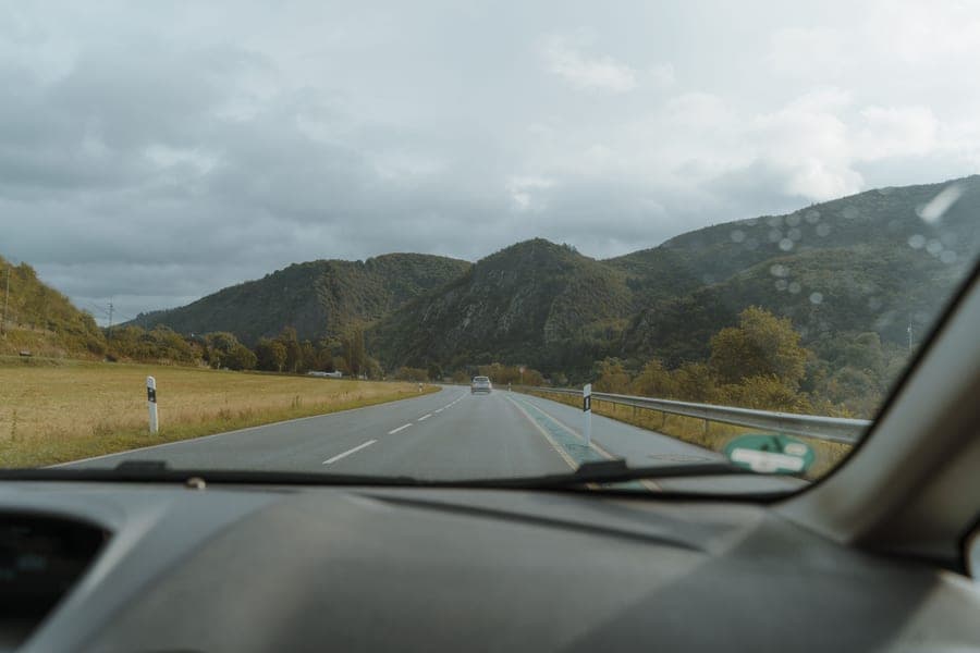 A scenic mountain road viewed from inside a car