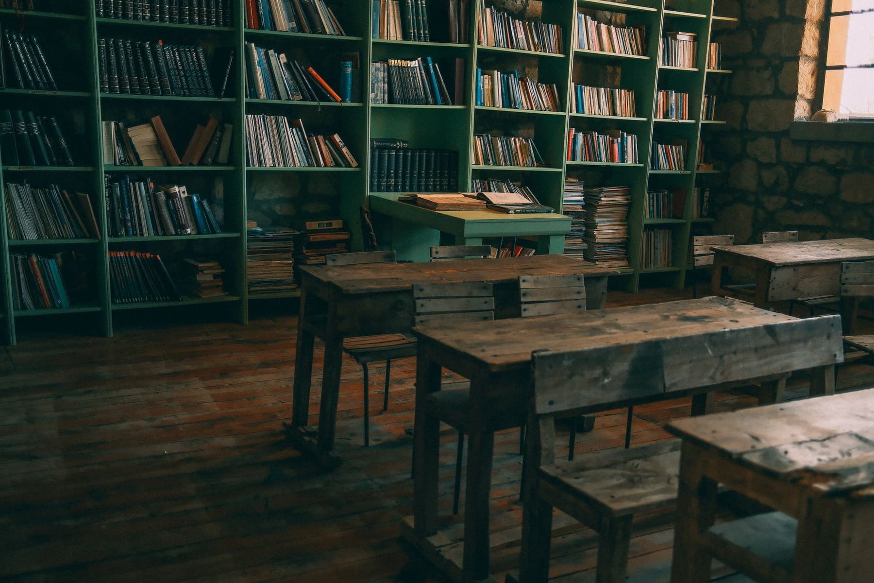 A quiet empty library reading room lined with desks