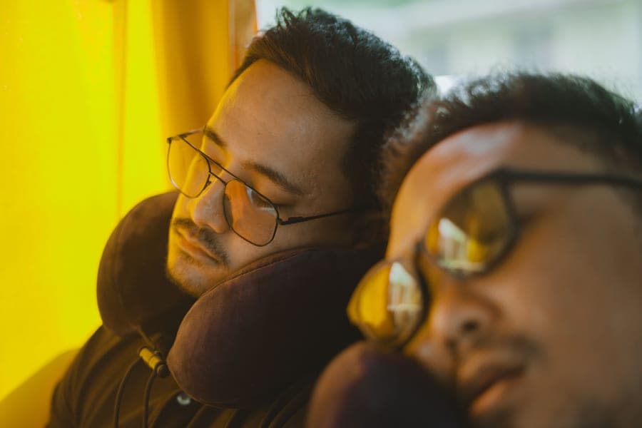 Two travelers asleep in transit wearing neck pillows