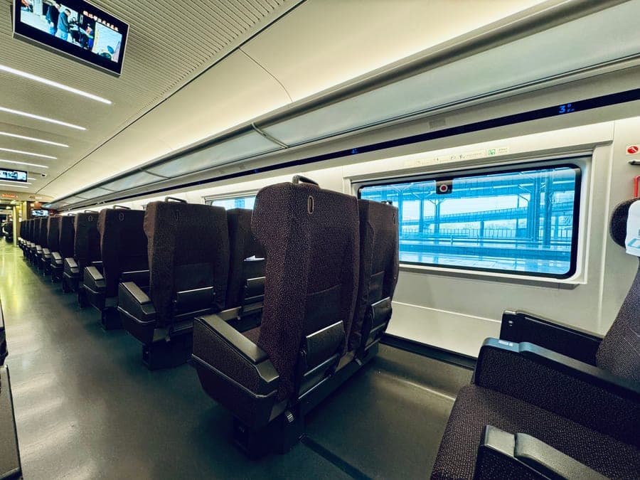 Spacious interior of a modern high-speed train with comfortable seating and large windows