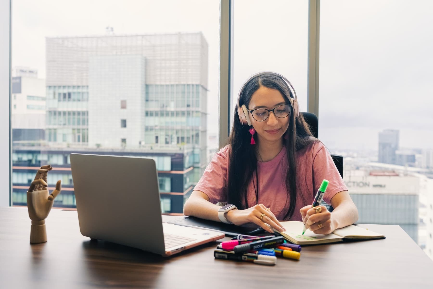 Headphones beside a notebook and pen on a desk